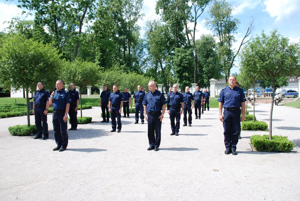 Policjanci stoją w czterech rzędach. Komendant  Miejski Policji w Białej Podlaskiej stoi przed policjantami i przemawia