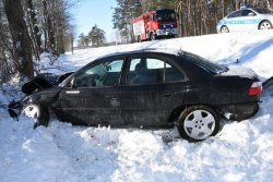 uszkodzony samochód oraz widoczne pojazdy służ ratunkowych: Policji i Straży Pożarnej